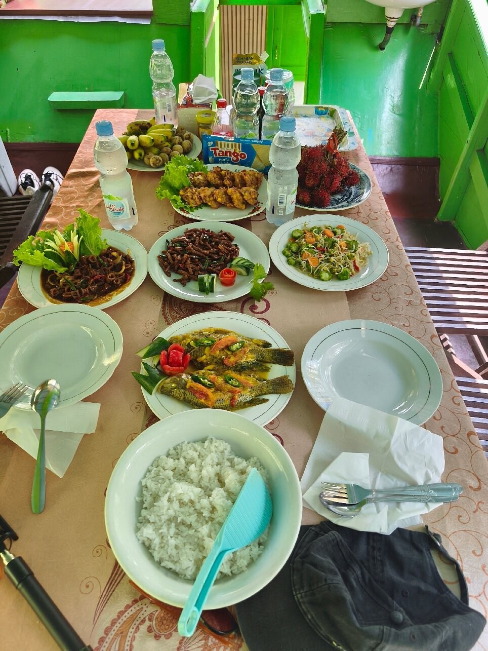 A full local Indonesian meal served on the klotok - fish, vegetables, rambutan, and more.