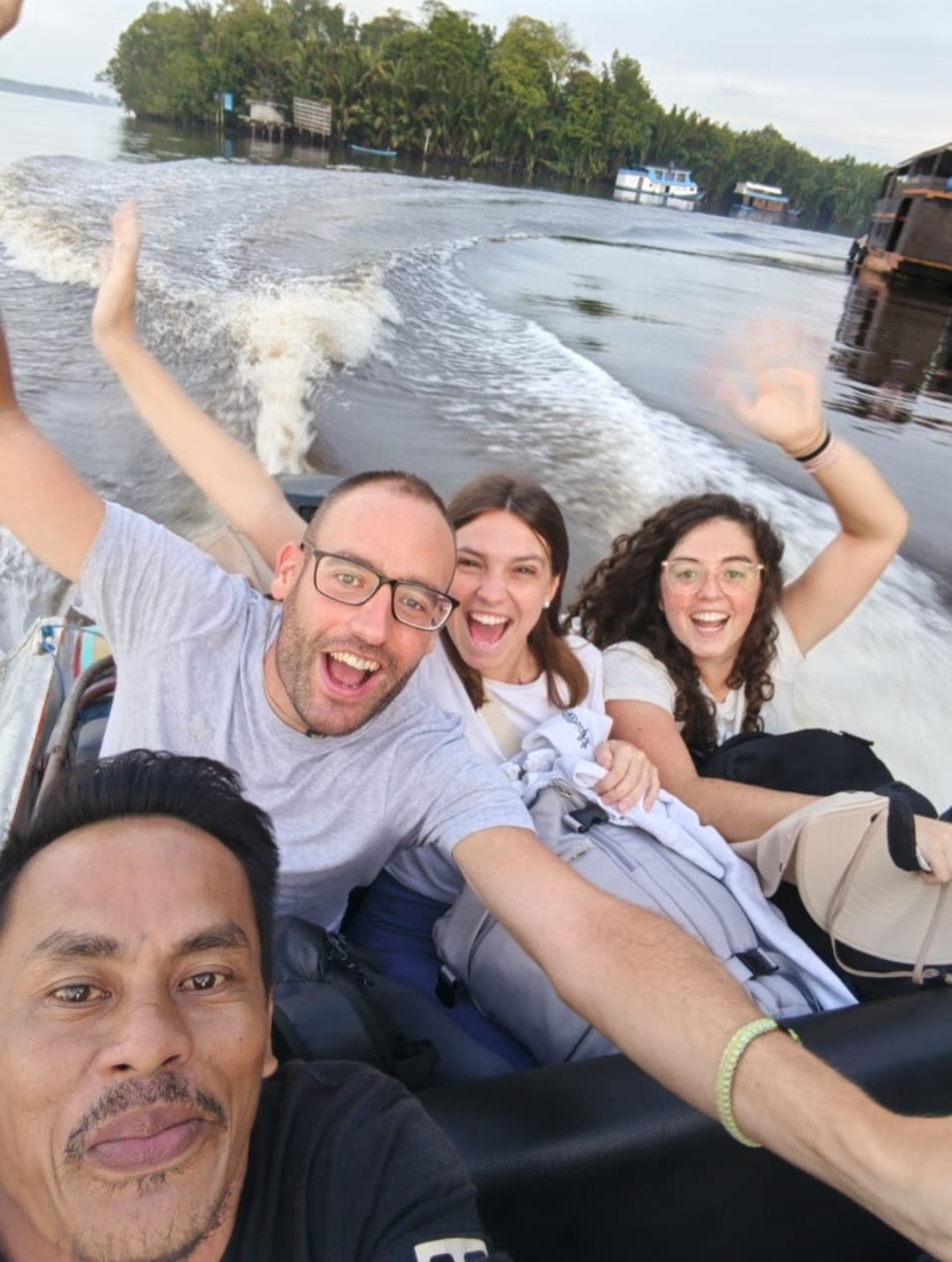 Guests cheering and laughing on a fast speedboat crossing the Kumai estuary.