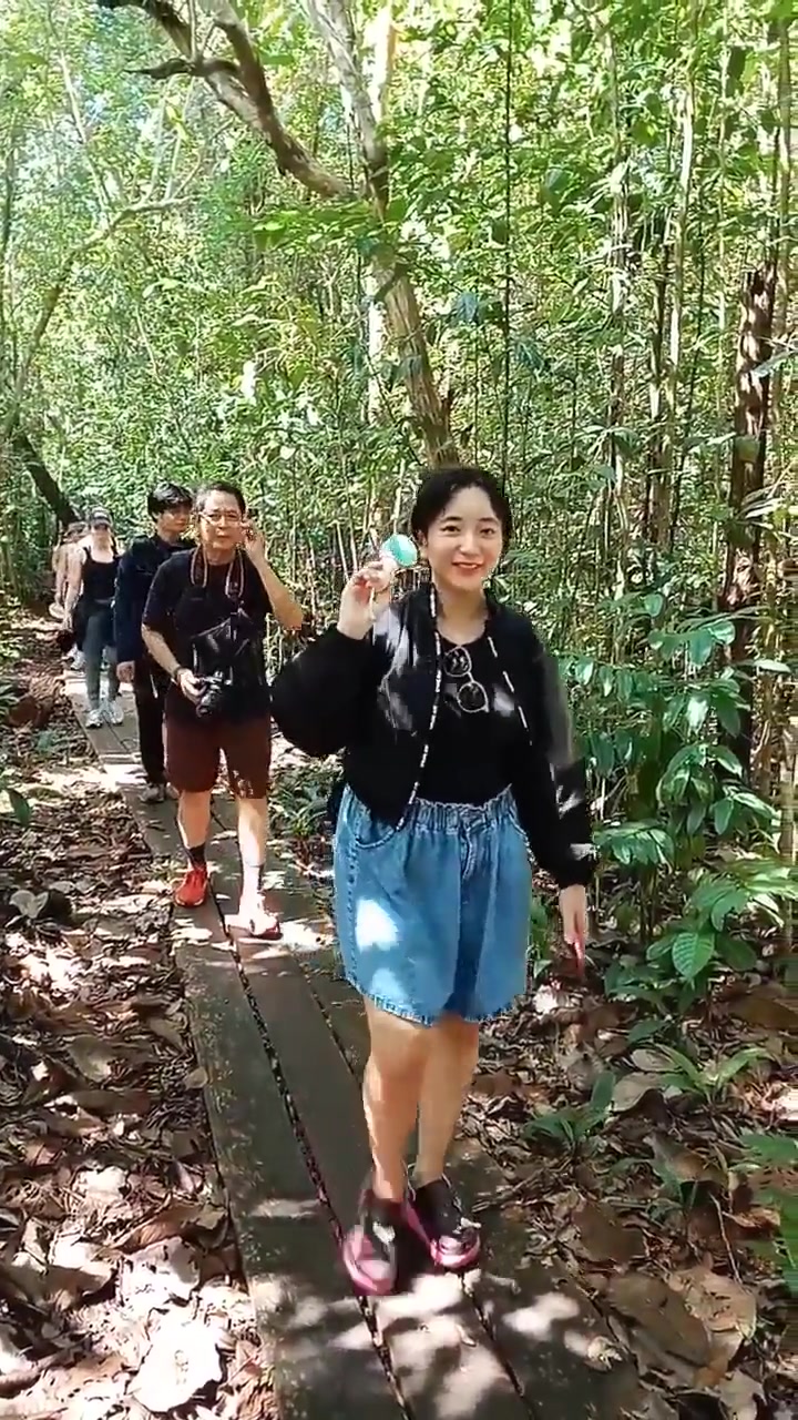 Guests walking through the lush jungle trail on a guided trek toward the orangutan feeding station.